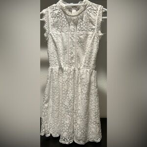 White lace fringe sleeveless dress. Never worn. Zip up and clasp on back.